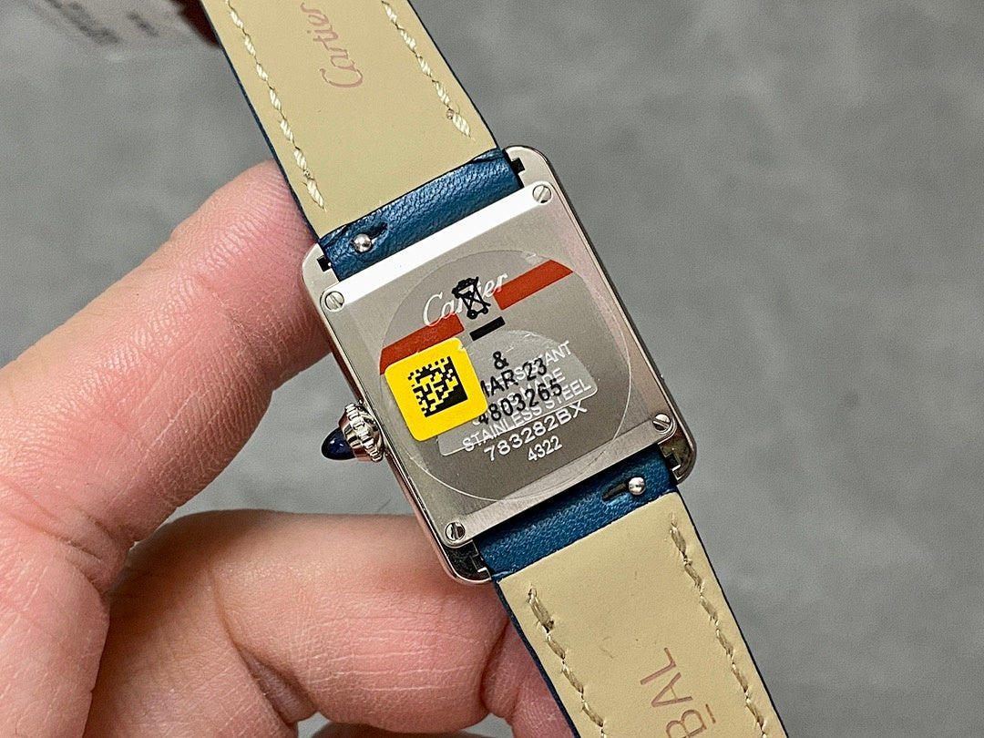 Blue leather watch with silver caseback and barcode label.
