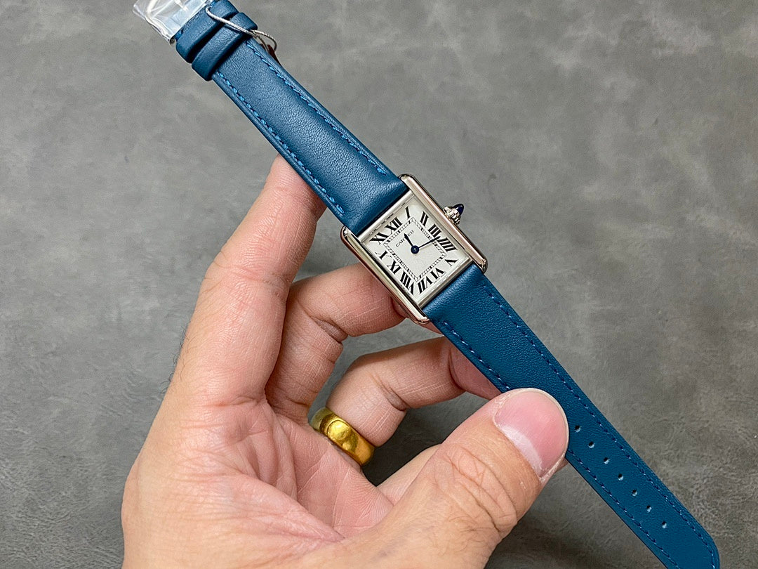 Blue leather strap wristwatch with square white dial and Roman numerals.