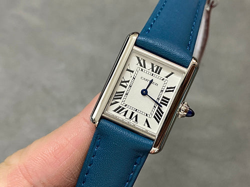 Blue leather strap wristwatch with silver square case and Roman numeral dial.