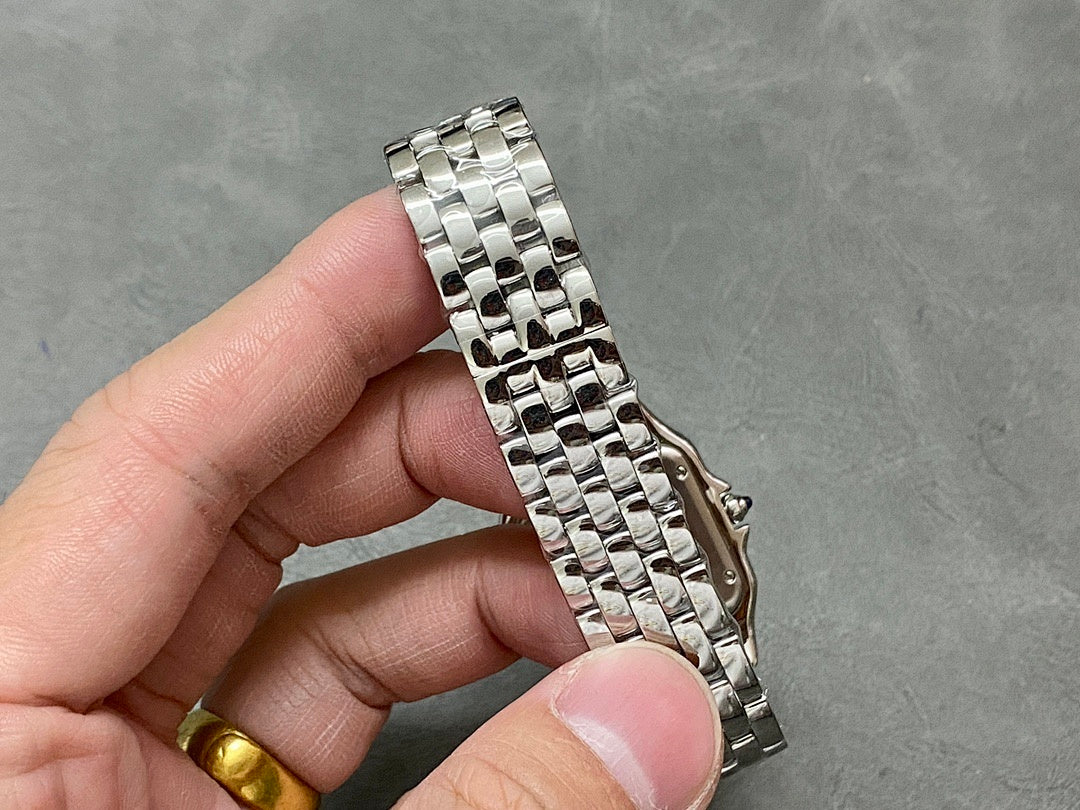 Silver-tone metal watch bracelet with linked links held in hand