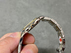 Cartier curved side view of two-tone metal case with crown and bezel details