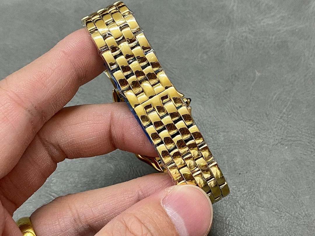 Gold Cartier watch bracelet links close-up held in hand.