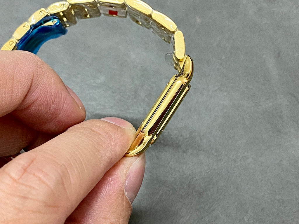 Gold Cartier watch band close-up around the wrist area, showing clasp.