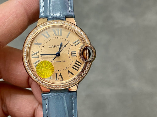 Cartier watch with cream dial, Roman numerals, gold case, and blue leather strap