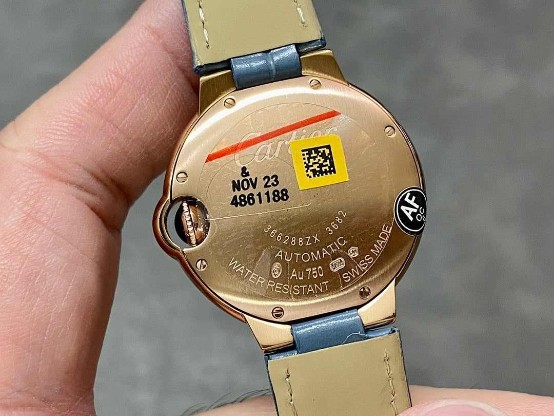 Back of Cartier watch in gold tone with case markings and blue leather strap