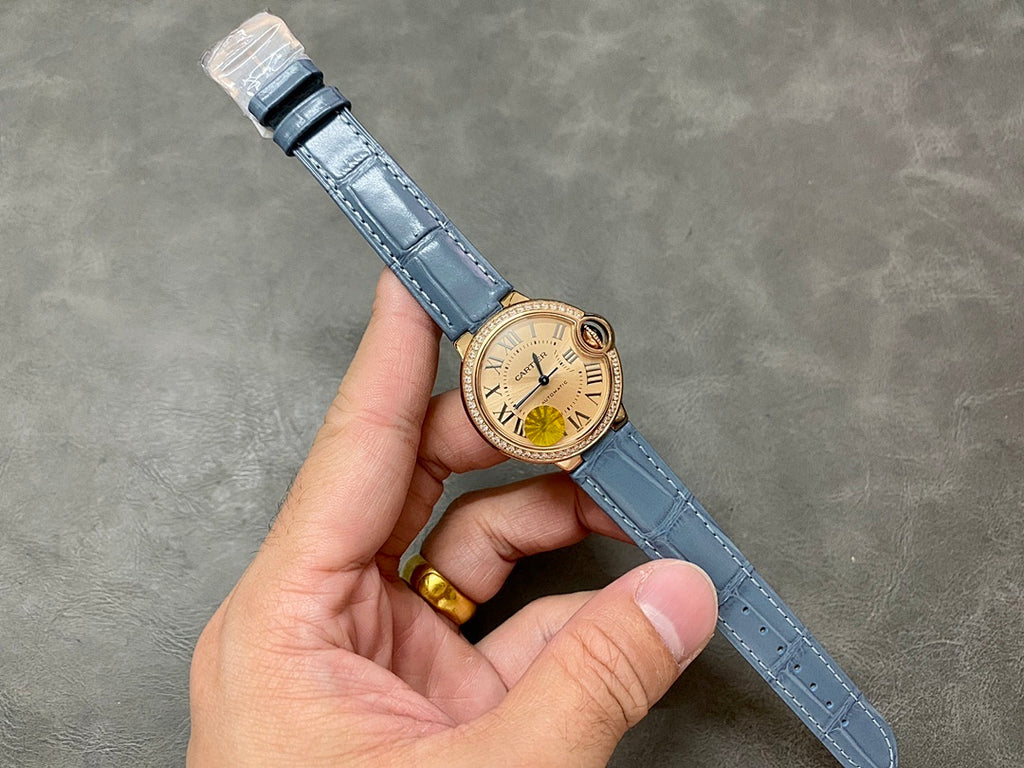 Cartier watch on blue leather strap with gold-toned case and cream dial