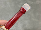 Red leather watch strap with gold-tone buckle and protective sleeve on clasp end