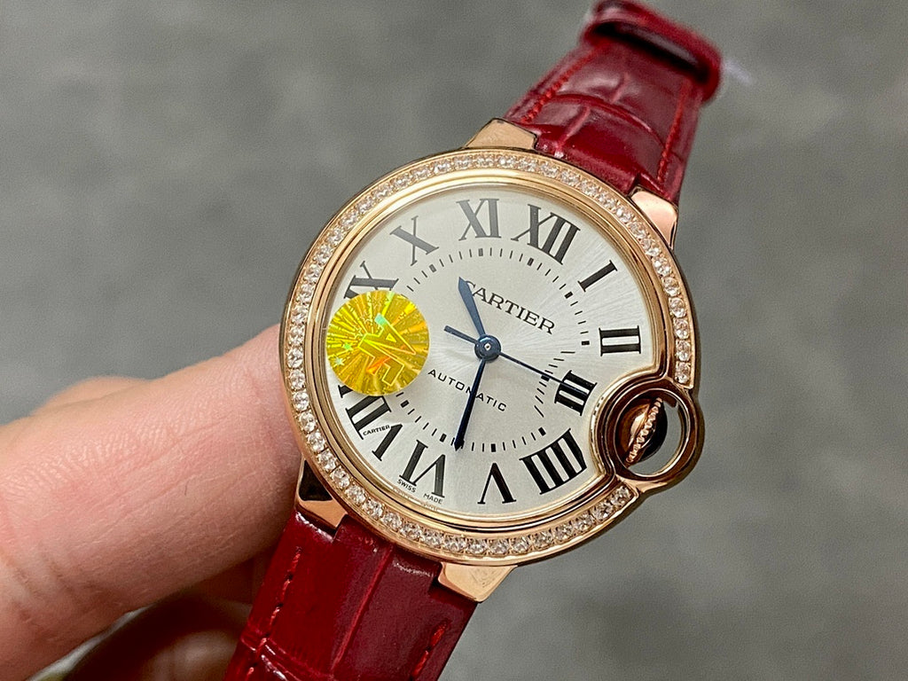 Round wristwatch with red leather strap and gold-tone case, jeweled bezel, Roman numerals dial
