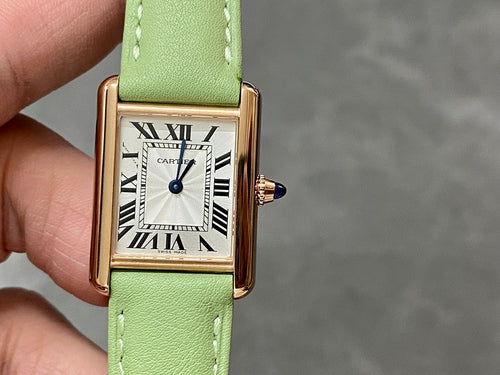 Cartier tank watch on green leather strap, gold-tone case, Roman numeral white dial