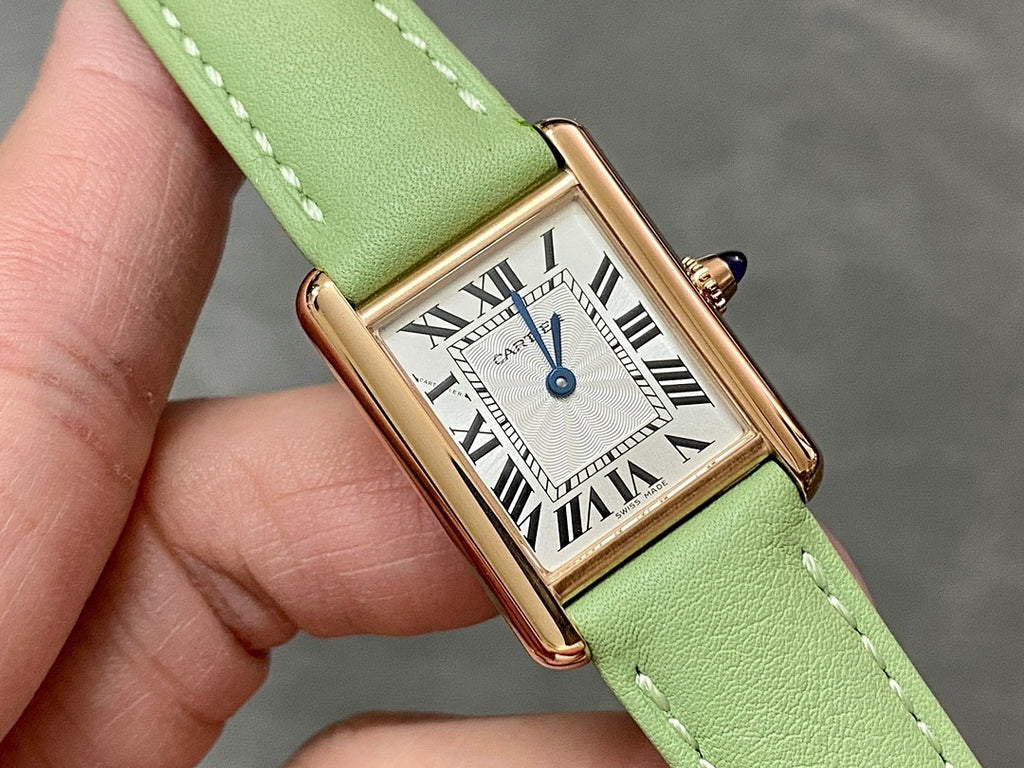 Cartier tank watch close-up with green leather strap, Roman numeral dial, gold-tone bezel