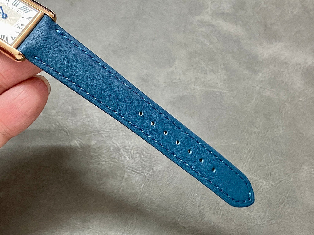 Blue leather watch strap with visible stitching and punched holes