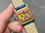 Cartier gold-tone watch back with blue leather strap and engraved markings