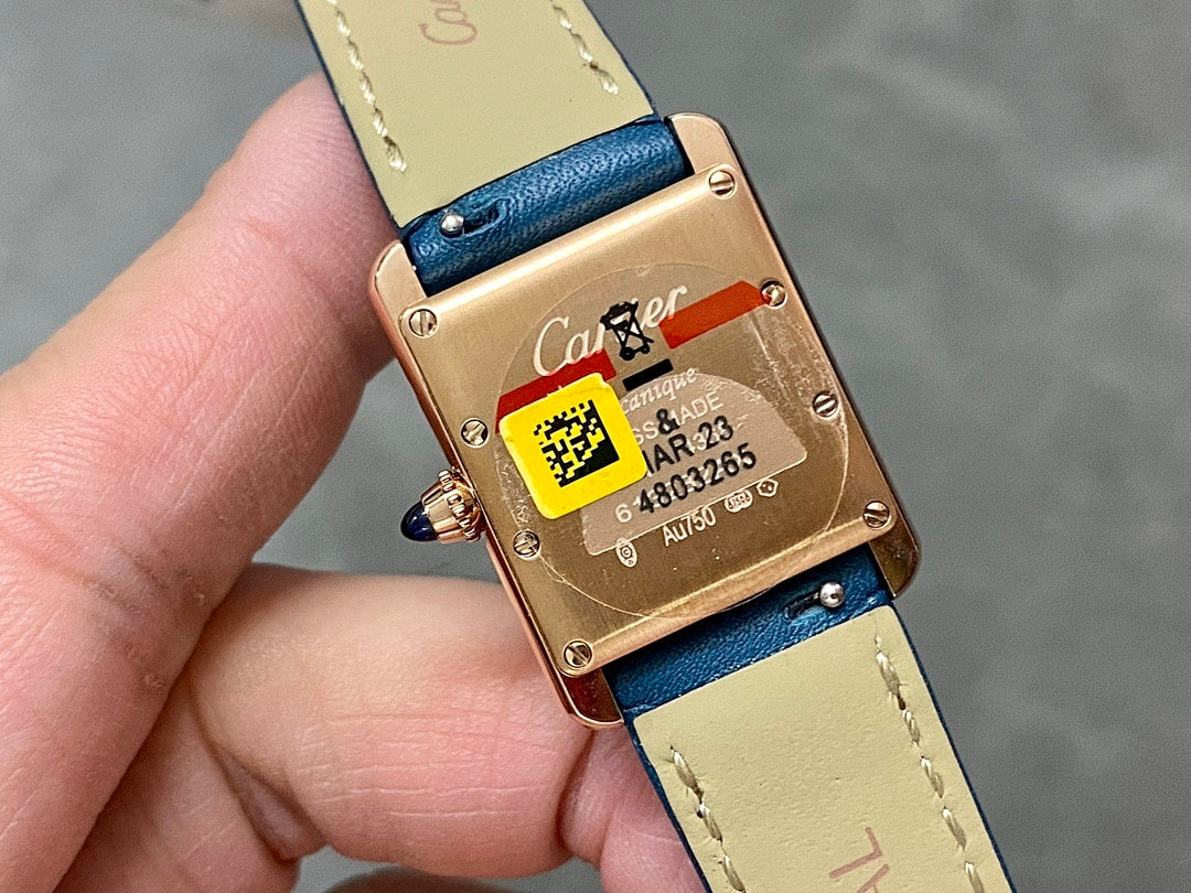 Cartier gold-tone watch back with blue leather strap and engraved markings