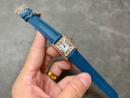 Cartier rectangular watch with blue leather strap, gold-tone case, white roman numeral dial