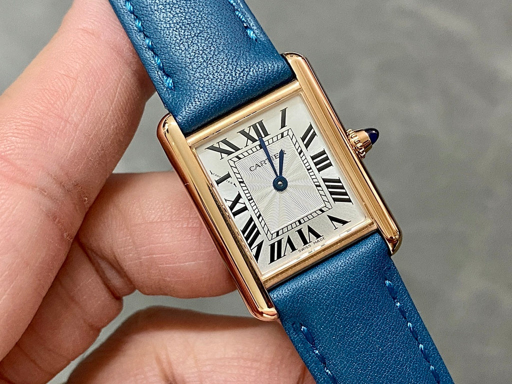 Cartier rectangular watch with blue strap, white dial, and blue-tone second hand