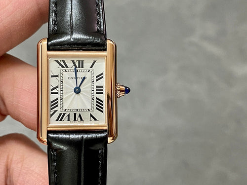 Cartier watch close-up on wrist: black leather strap, gold-toned case, white dial