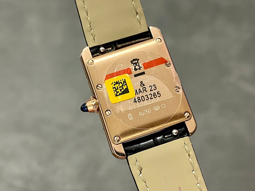 Cartier watch caseback with gold-toned plate, QR-style label, and black strap
