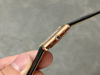Cartier watch side view with black strap, gold-toned case edge, and blue accents