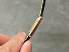 Cartier watch side profile with gold-toned case and black leather strap