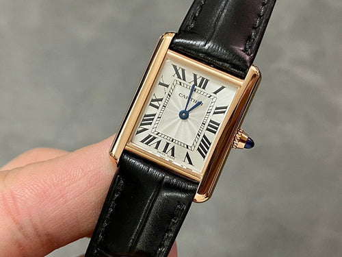 Cartier watch with black leather strap, gold-toned case, white dial and Roman numerals