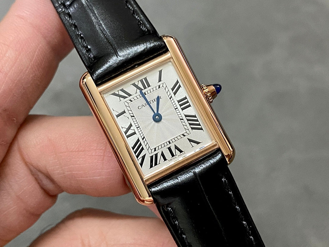 Cartier watch front view with black leather strap, gold-toned case, white dial and blue hands