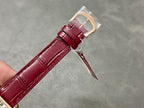 Burgundy leather watch strap with gold-tone clasp and small safety pin