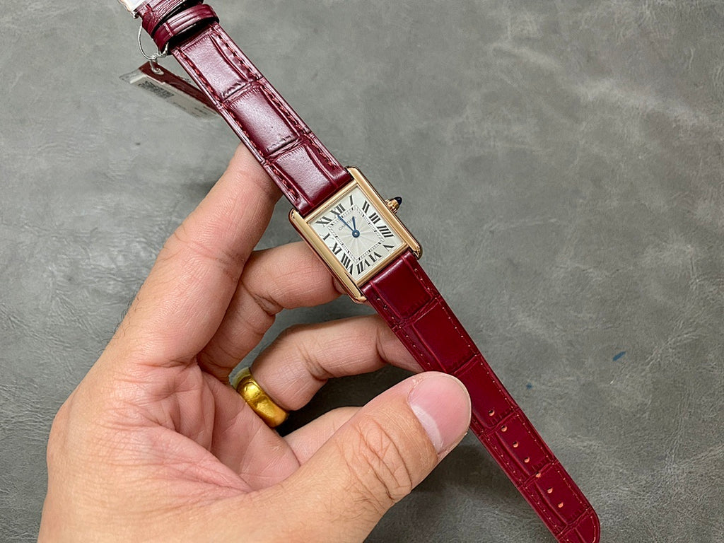 Cartier tank watch on burgundy strap with gold-tone case and Roman numeral dial