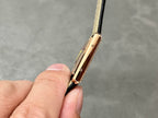 Cartier rose-gold watch profile with crown and strap lugs, on black leather strap.