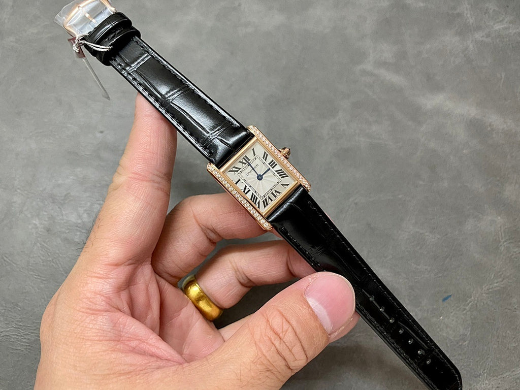 Cartier wristwatch with black leather strap and rose-gold case, Roman numeral dial.
