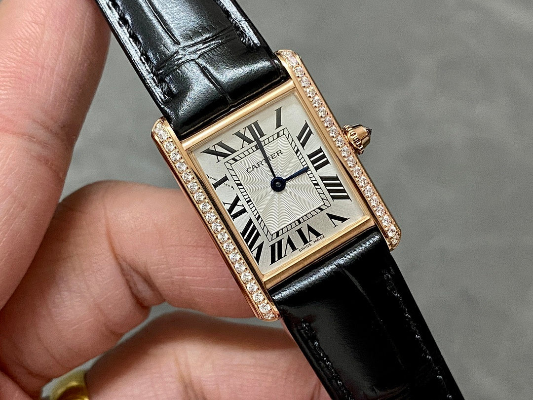 Close-up Cartier rose-gold wristwatch with black leather strap, diamond bezel, Roman dial.