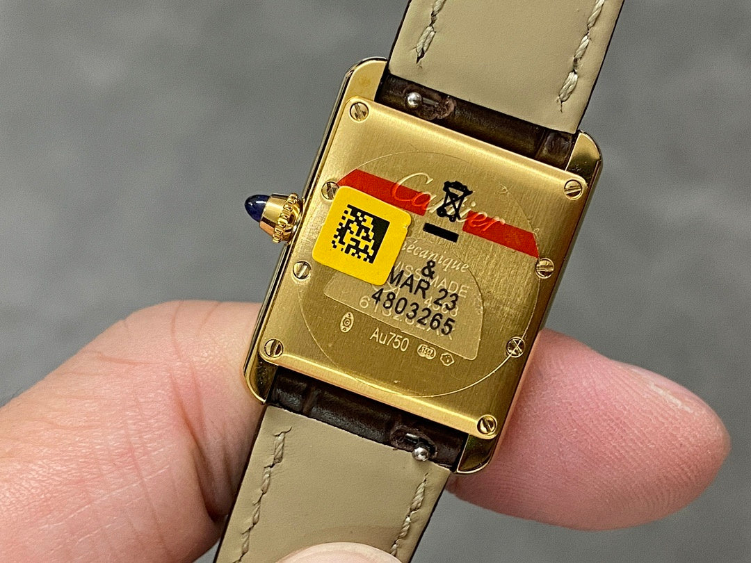 Cartier watch caseback on light leather strap, gold back with engraved markings