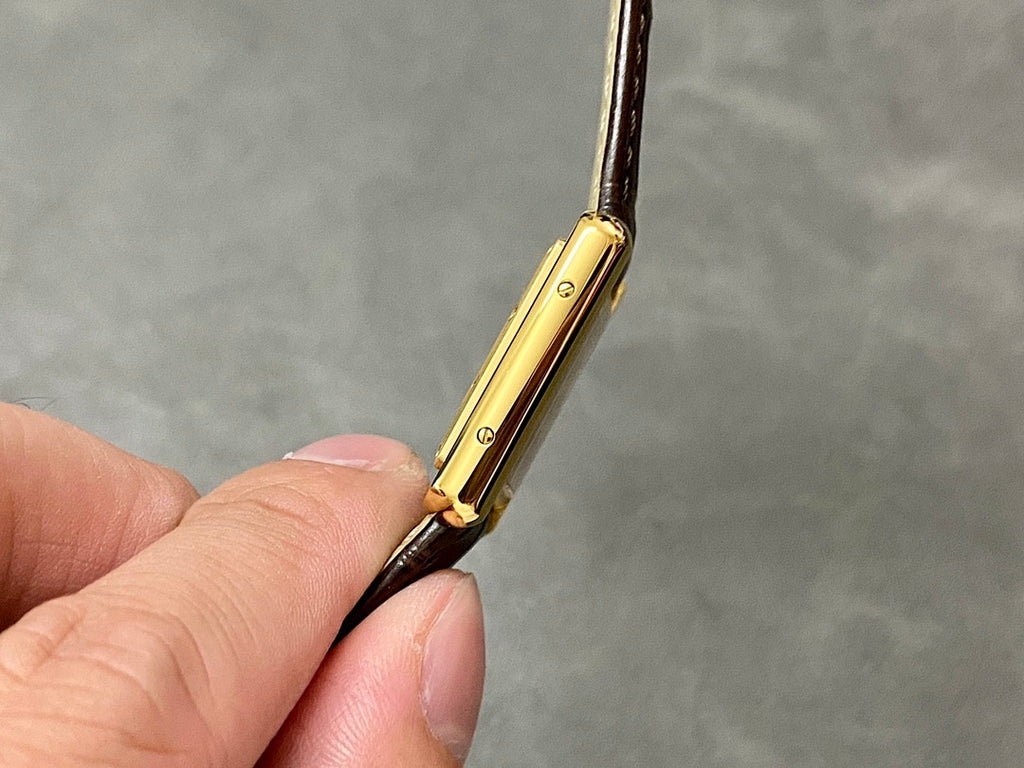 Cartier watch gold case side profile with brown leather strap and lugs
