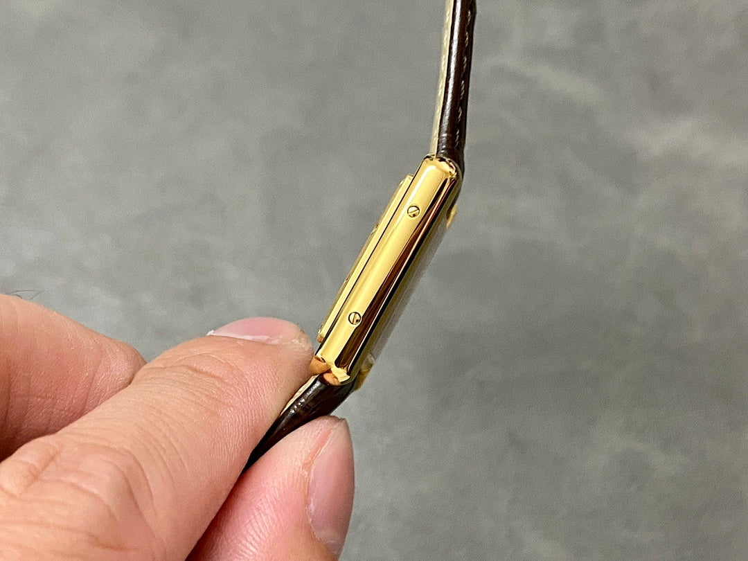 Cartier watch gold case side profile with brown leather strap and lugs