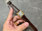 Cartier watch on brown leather strap with gold buckle, white dial and Roman numerals