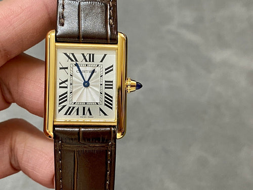 Gold-tone rectangular wristwatch with Roman numeral dial and brown leather strap, side view