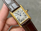 Rectangular wristwatch with gold-tone case, Roman numeral dial, and brown leather strap close-up