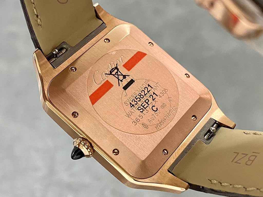 Cartier Santos watch caseback with rose-gold finish and black leather strap.