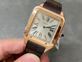 Cartier Santos watch with rose-gold case, black leather strap, Roman numeral dial.