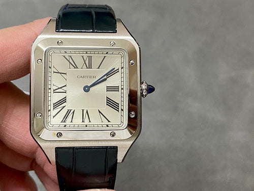 Cartier rectangular watch on hand; black leather strap, Roman dial, silver case, crown.