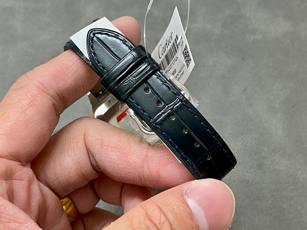 Cartier watch with black leather strap and silver case, angled view; crown visible.