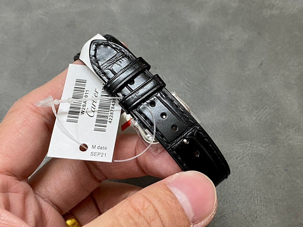 Cartier watch with black leather strap underside and case back with tag.