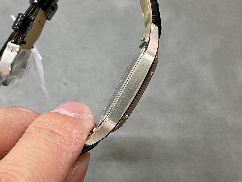 Cartier watch side profile showing polished case and black leather strap.