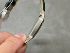 Cartier watch curved side view with dark leather strap and silver-toned case.