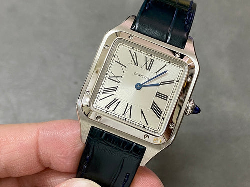 Cartier watch with black leather strap, square silver case, Roman numeral dial.