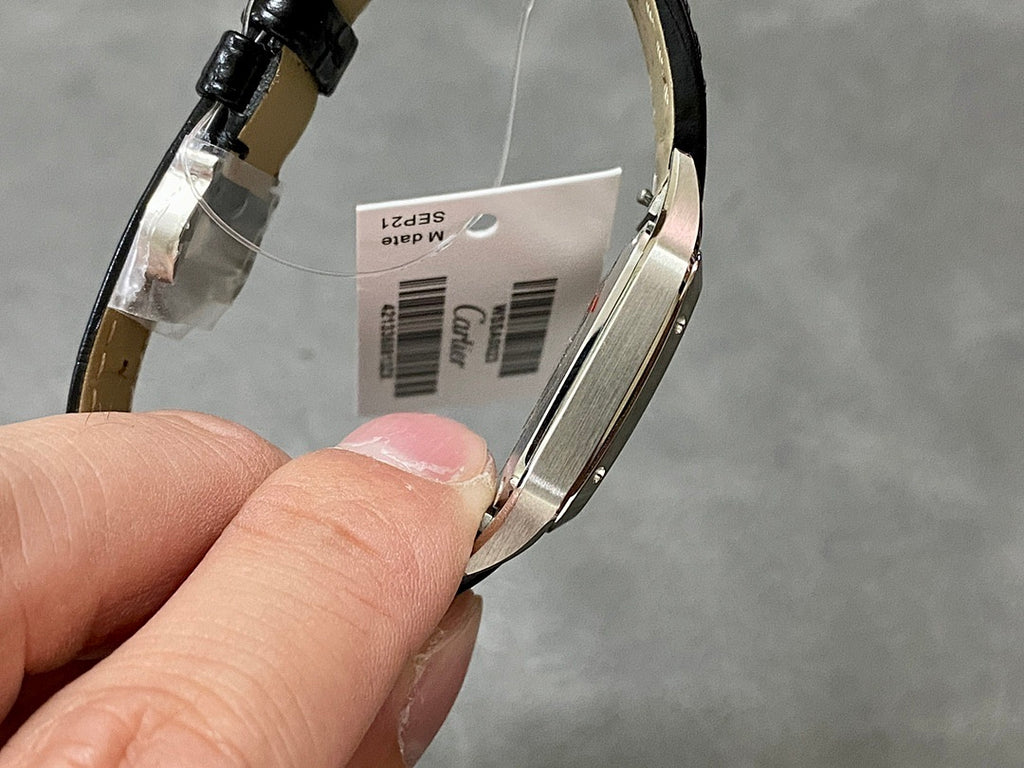 Cartier watch underside view, black leather strap and silver case with barcode sticker