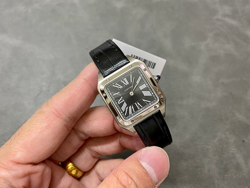 Cartier watch on hand, black leather strap and silver rectangular case with Roman numeral dial