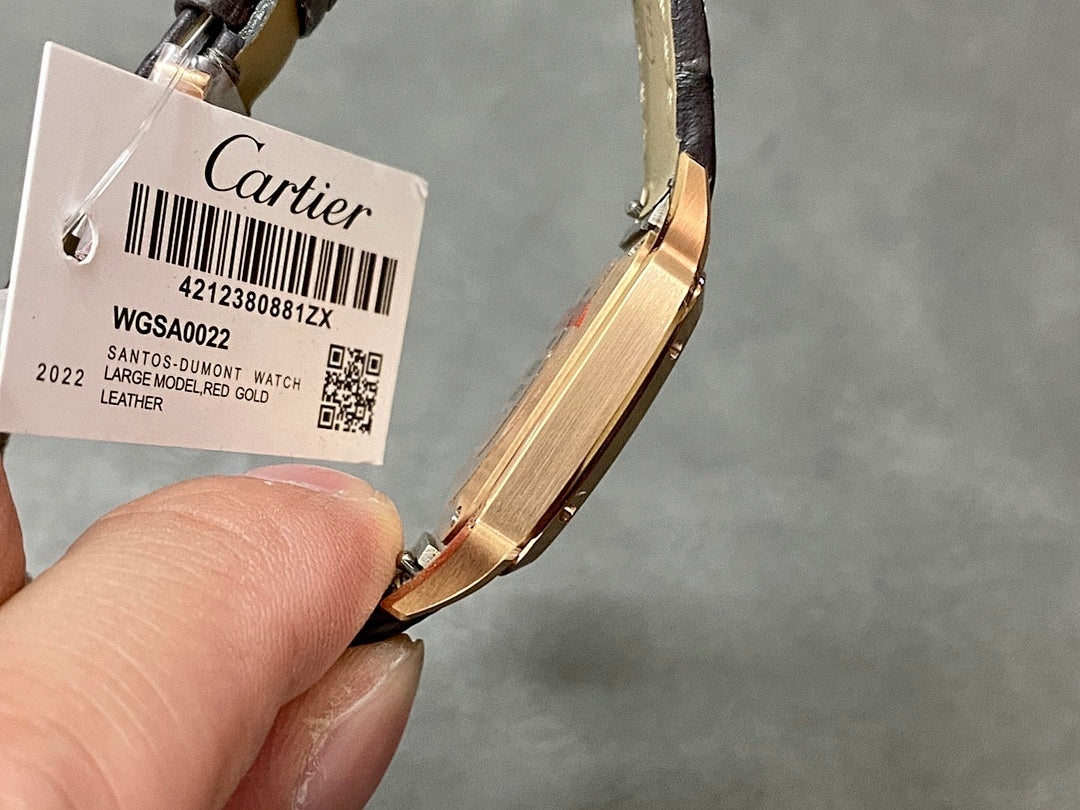 Wristwatch with black leather strap and tag showing barcode, gold-tone case.