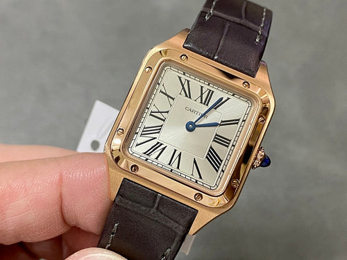 Gold-tone Cartier-style wristwatch with black leather strap, Roman numeral dial, blue crown.