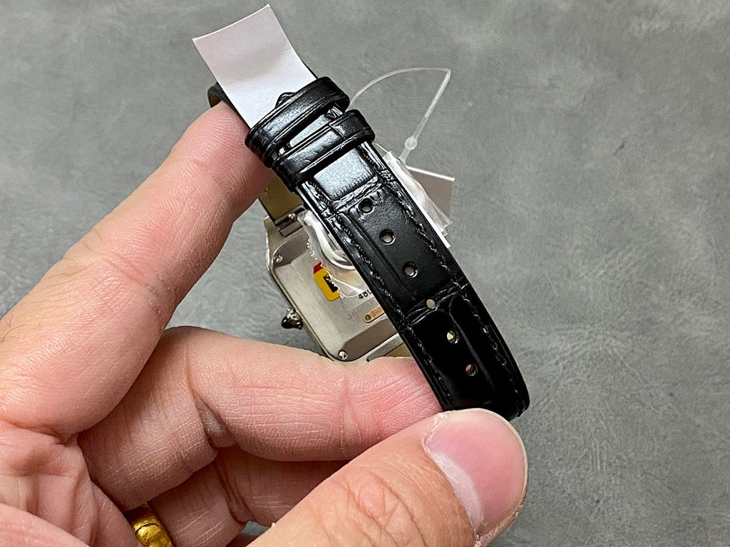 Cartier watch with black leather strap and metal case underside, visible clasp hardware