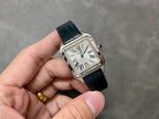 Cartier wristwatch front view with white dial, black leather strap, blue hands